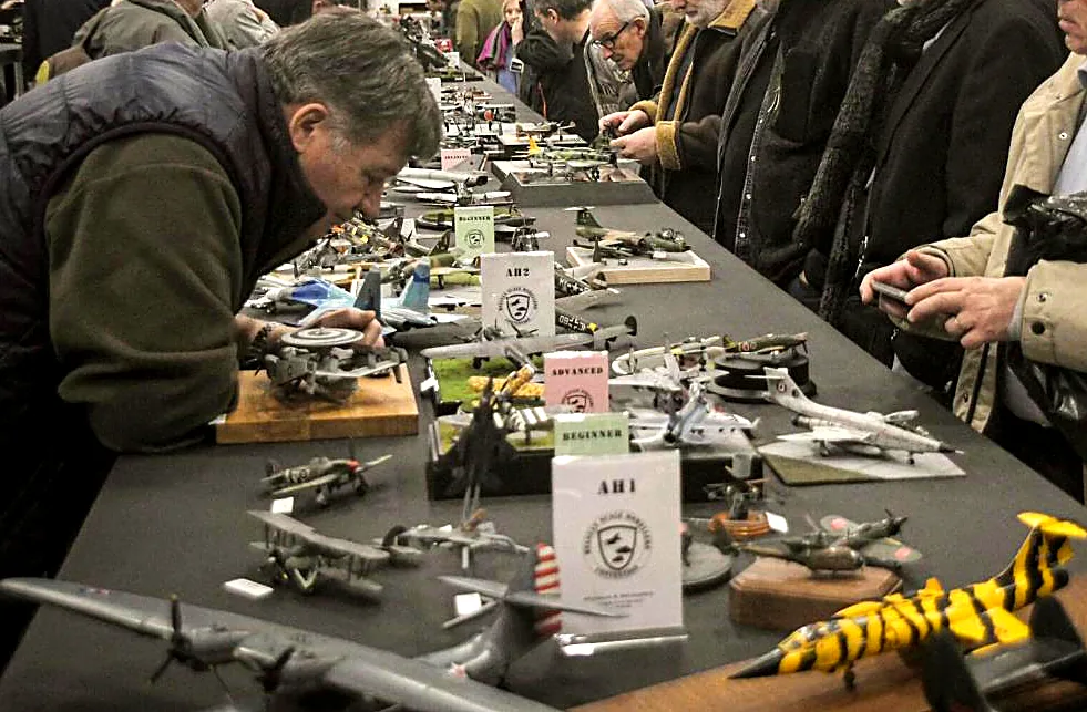 Des visiteurs étudient les maquettes sur la table du concours
